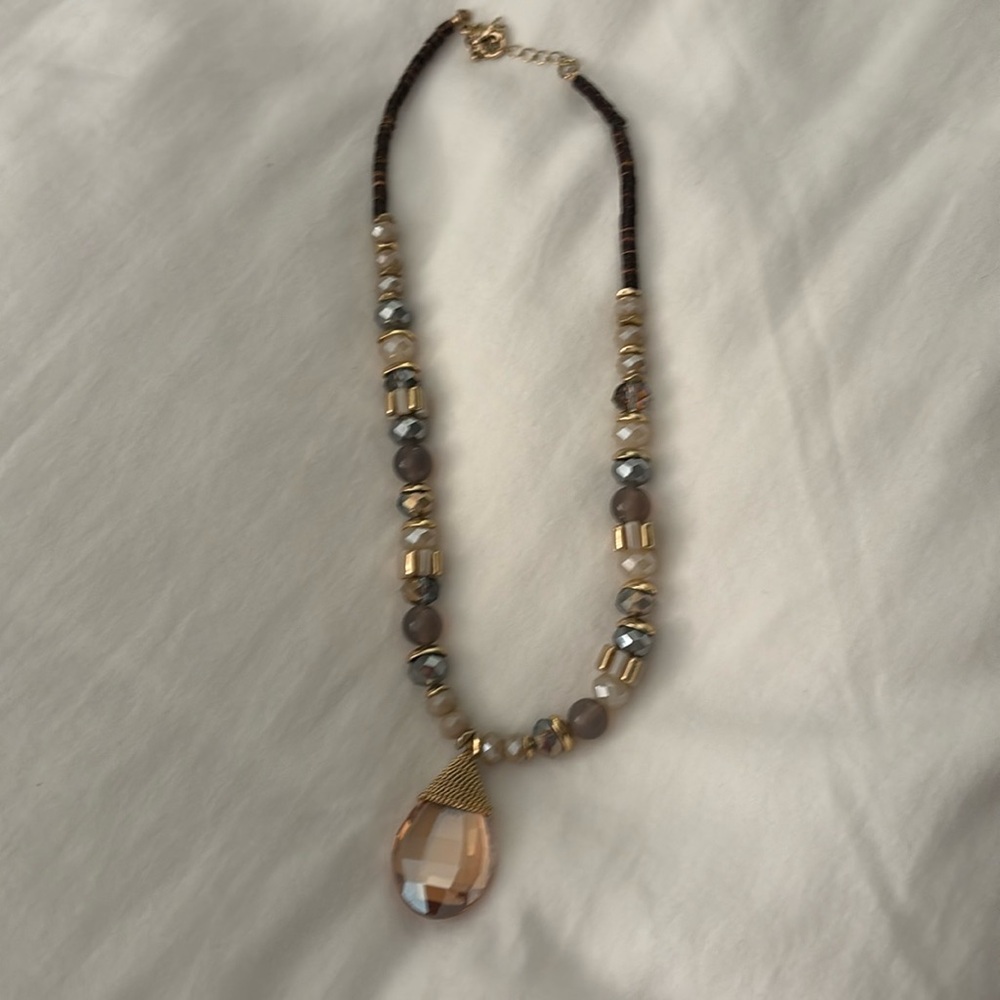 Bead necklace with gold and stone hanging from bottom